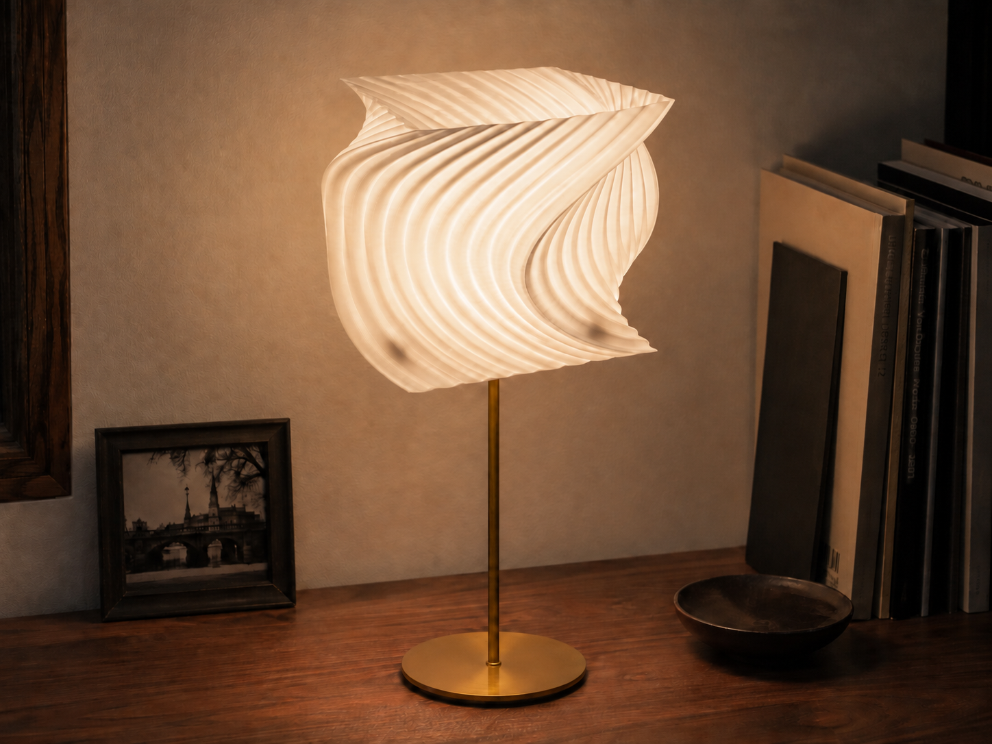 Arc Cascade lighting object glowing beside design books
